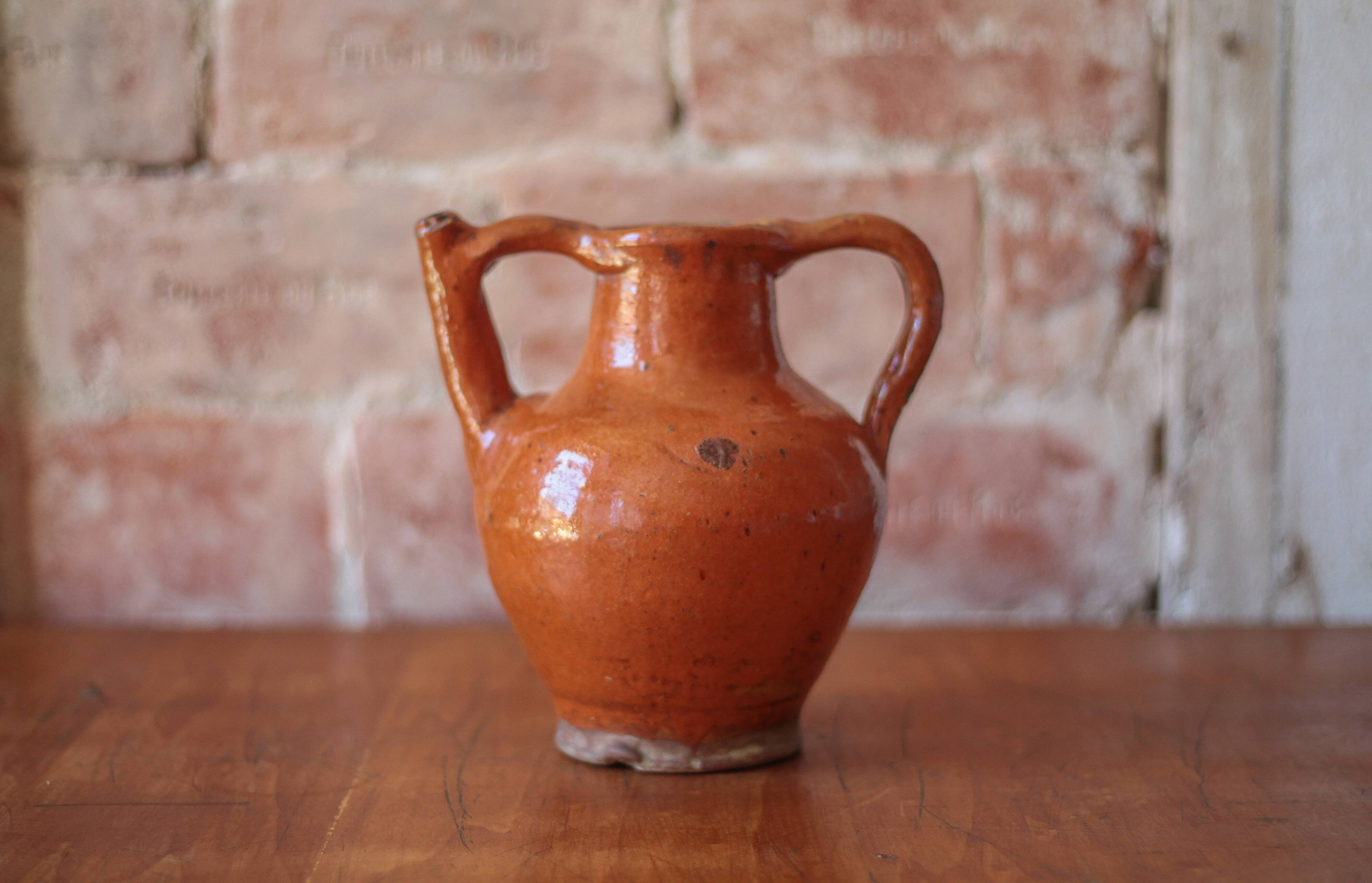 Ancient Orjol jug in orange glazed terracotta from South West France, 19th century.
