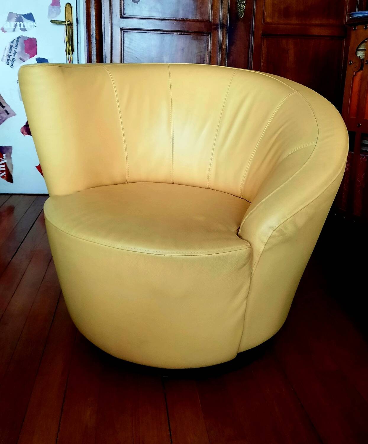 Pair of yellow leather swivel armchairs with asymmetrical armrests, circa 1980