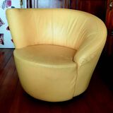 Pair of yellow leather swivel armchairs with asymmetrical armrests, circa 1980