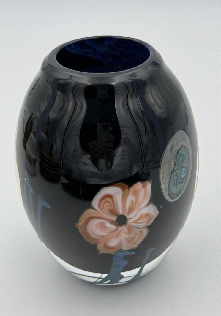 Double-lined blown glass vase with flower inclusions.