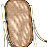 Modernist rocking chair in gilded brass and cane.