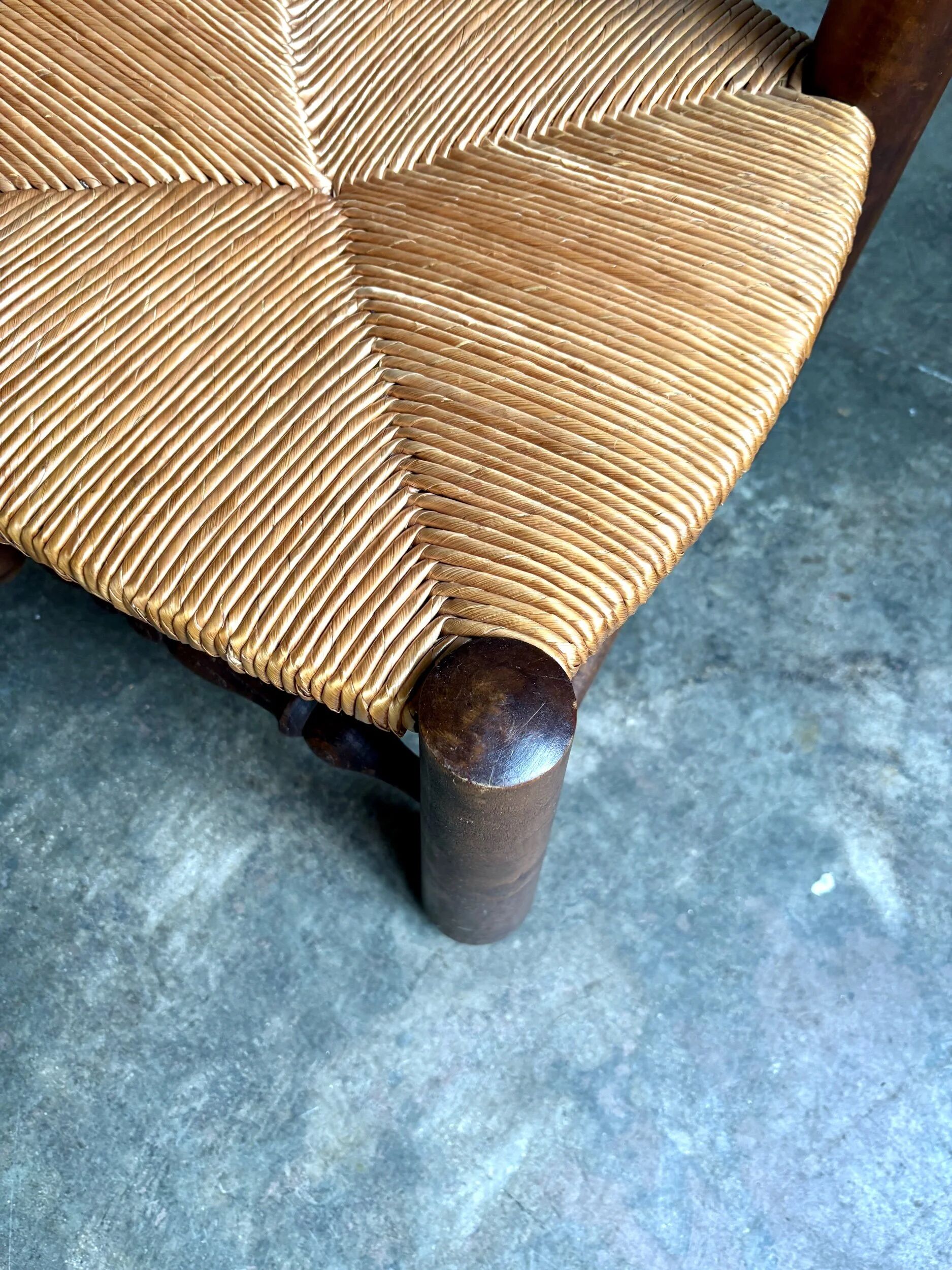 Brutalist low chair in dark wood and straw no. 1