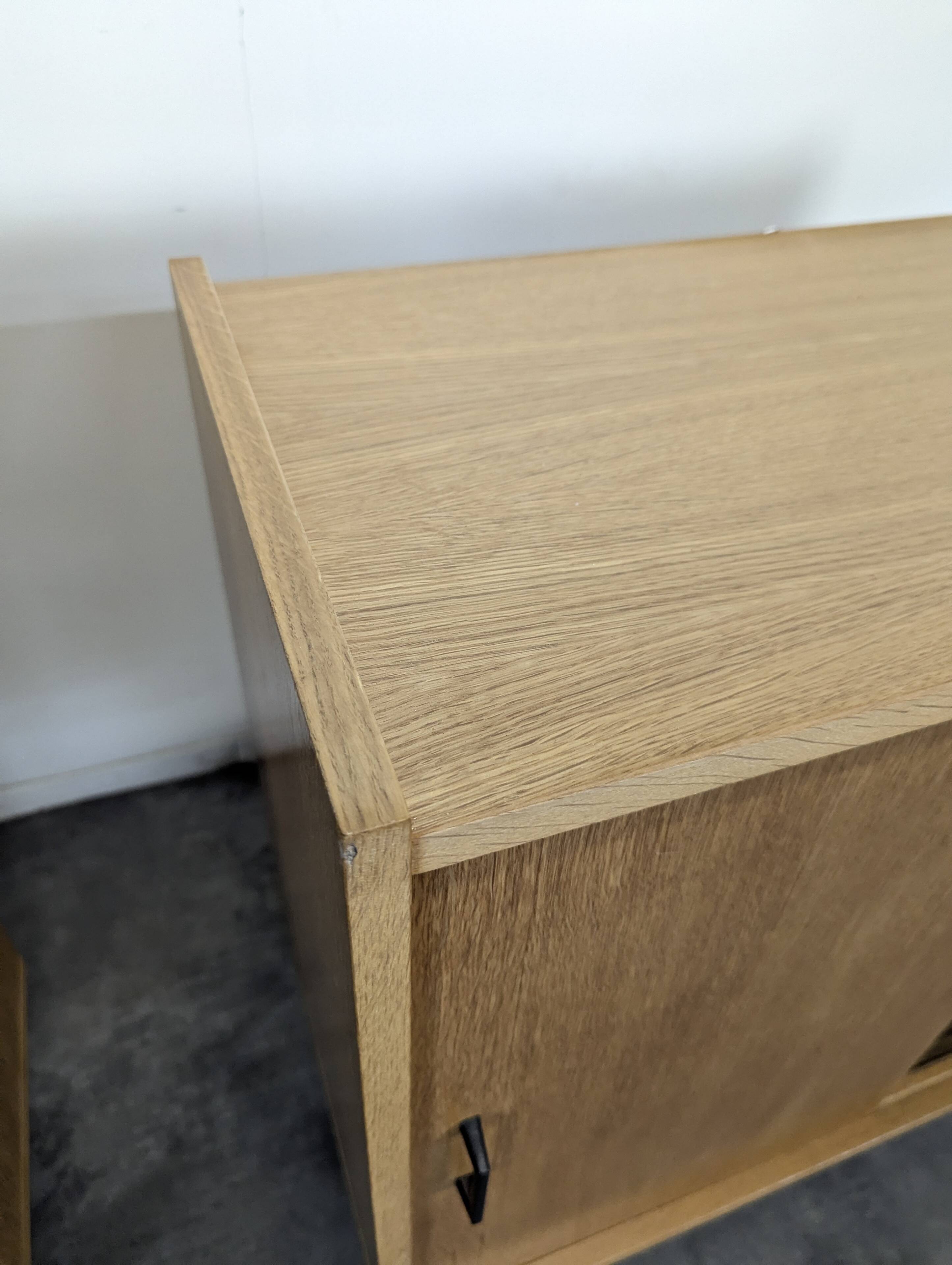 Pair of modernist sideboards with black glass doors in oak veneer.