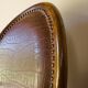 Antique armchair in solid wood and patinated brown leather, early 20th century.