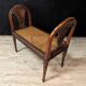 Louis XVI bench in walnut with cane seating.
