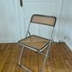 Vintage folding chair in metal and cane.