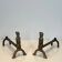 Pair of bronze andirons with seated shamans monogrammed Anton Prinner