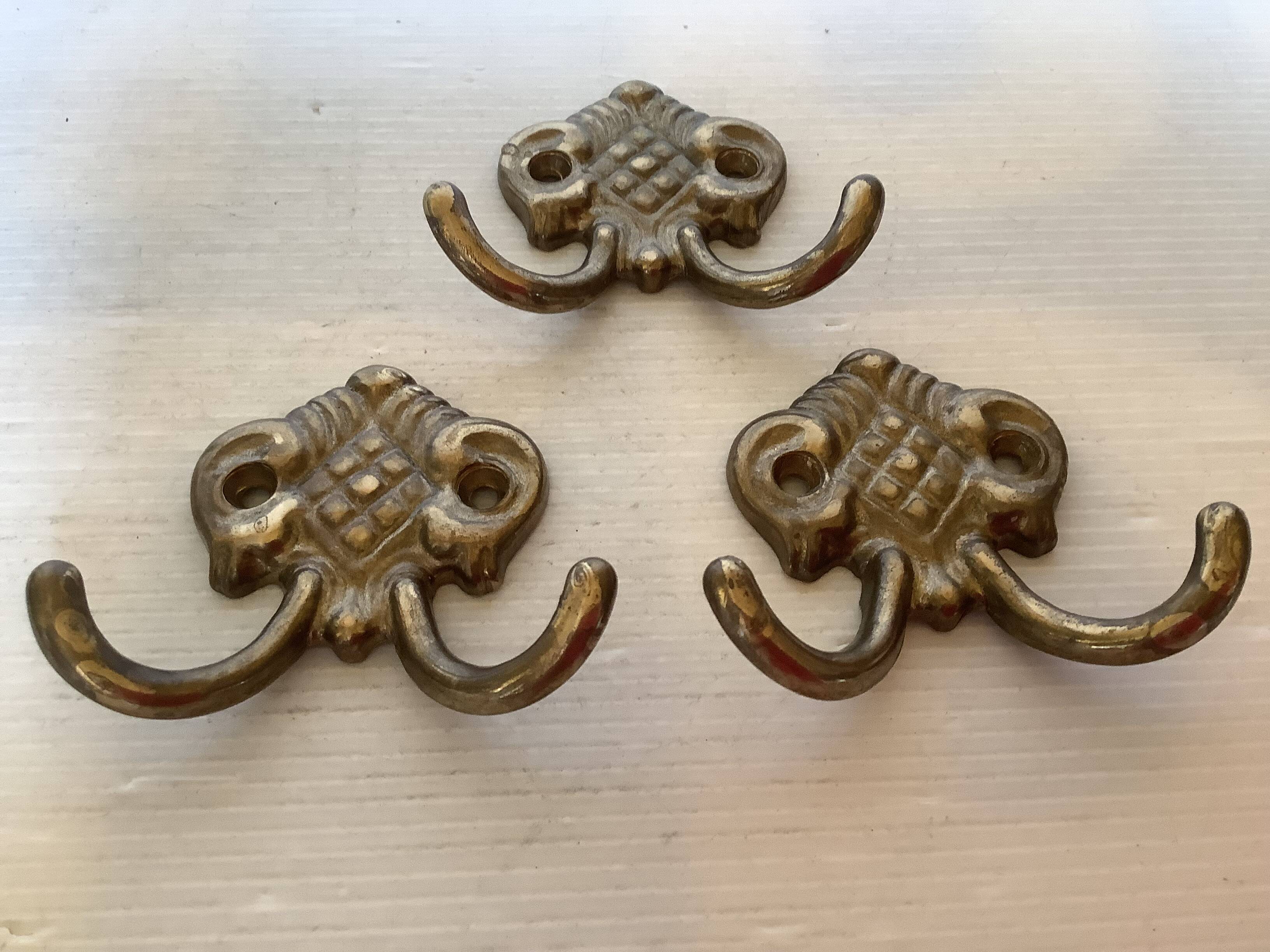 Three double brass coat hooks.