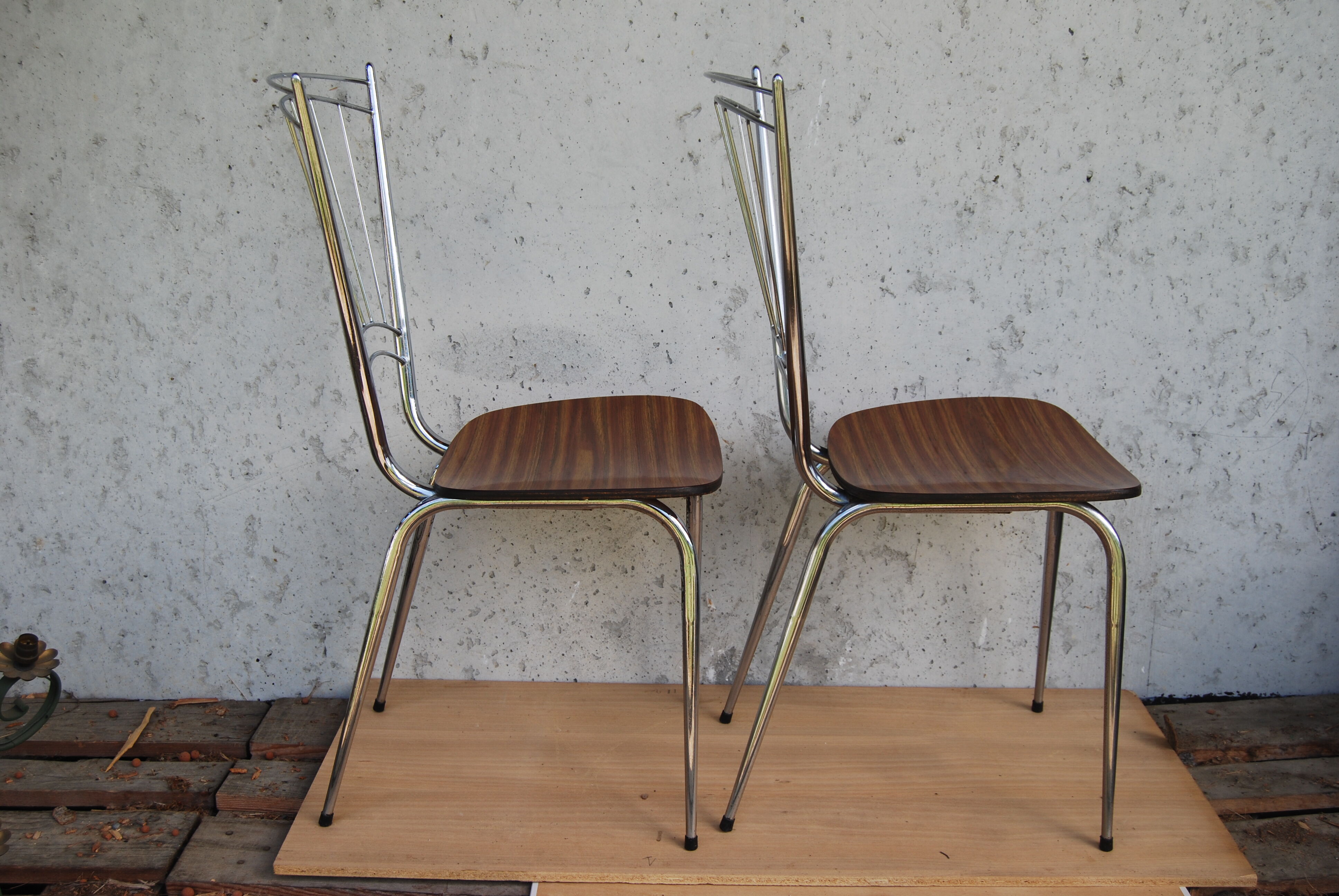 Pair of formica chairs with chrome metal backs in the shape of a lyre.
