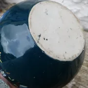 Old ceramic jug with flowers or single-stem vase.