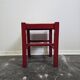 Tabouret en bois rouge avec assise en paille tressée.