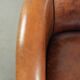 Sheepskin club armchair with deep warm colours and black piping