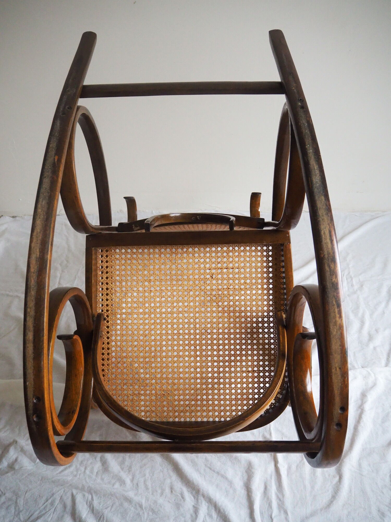 Rocking-chair en bois teinté et assise cannée