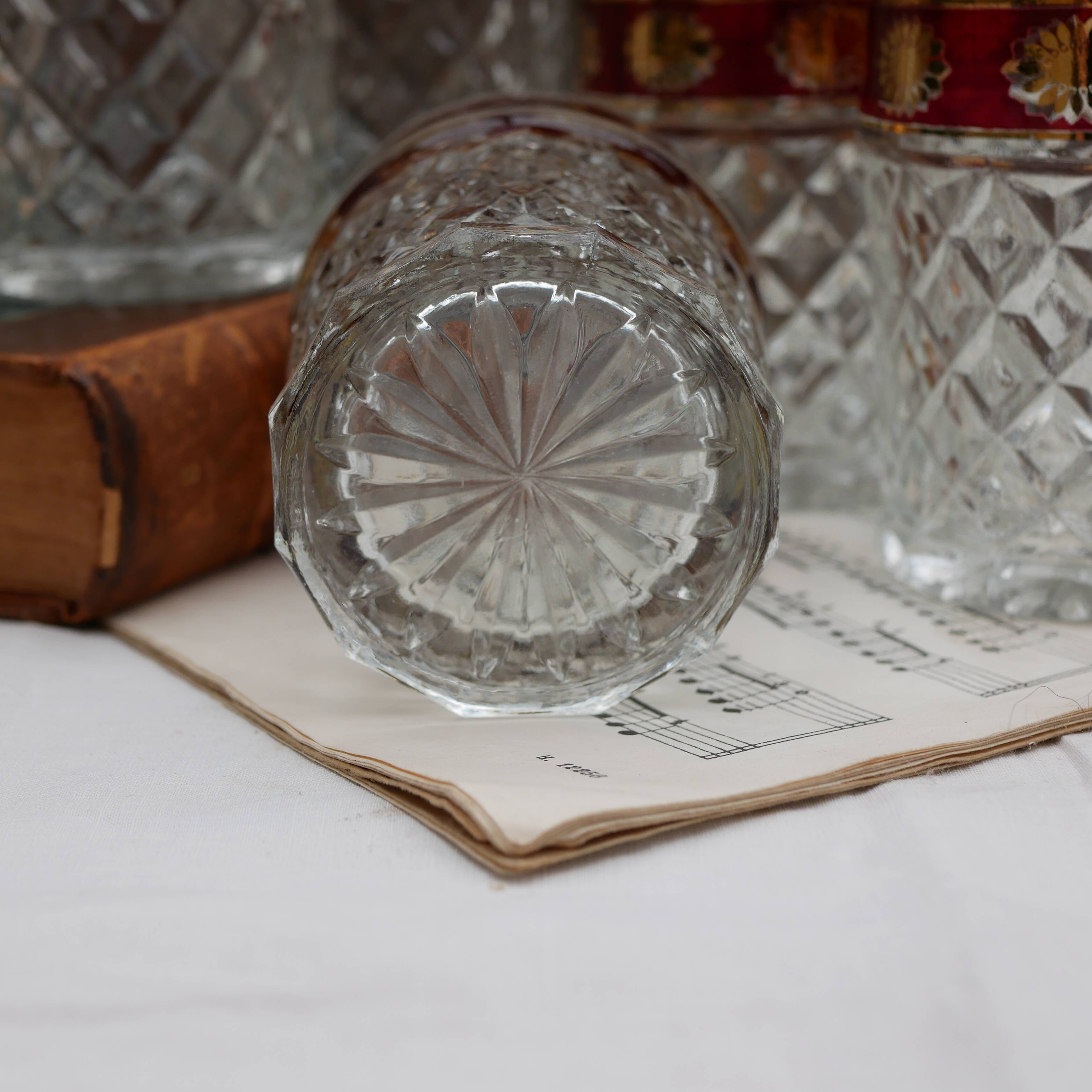 Six pressed glass whisky glasses with red and gold rims