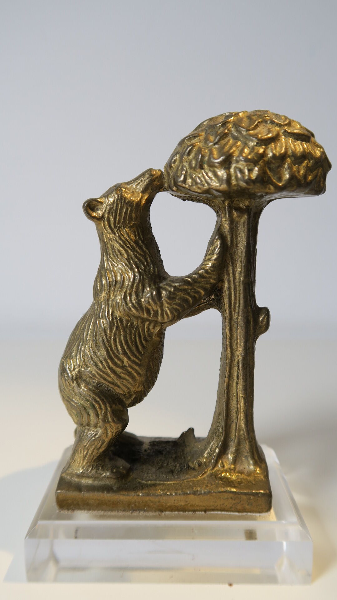 Brass sculpture, bear looking for honey in the tree