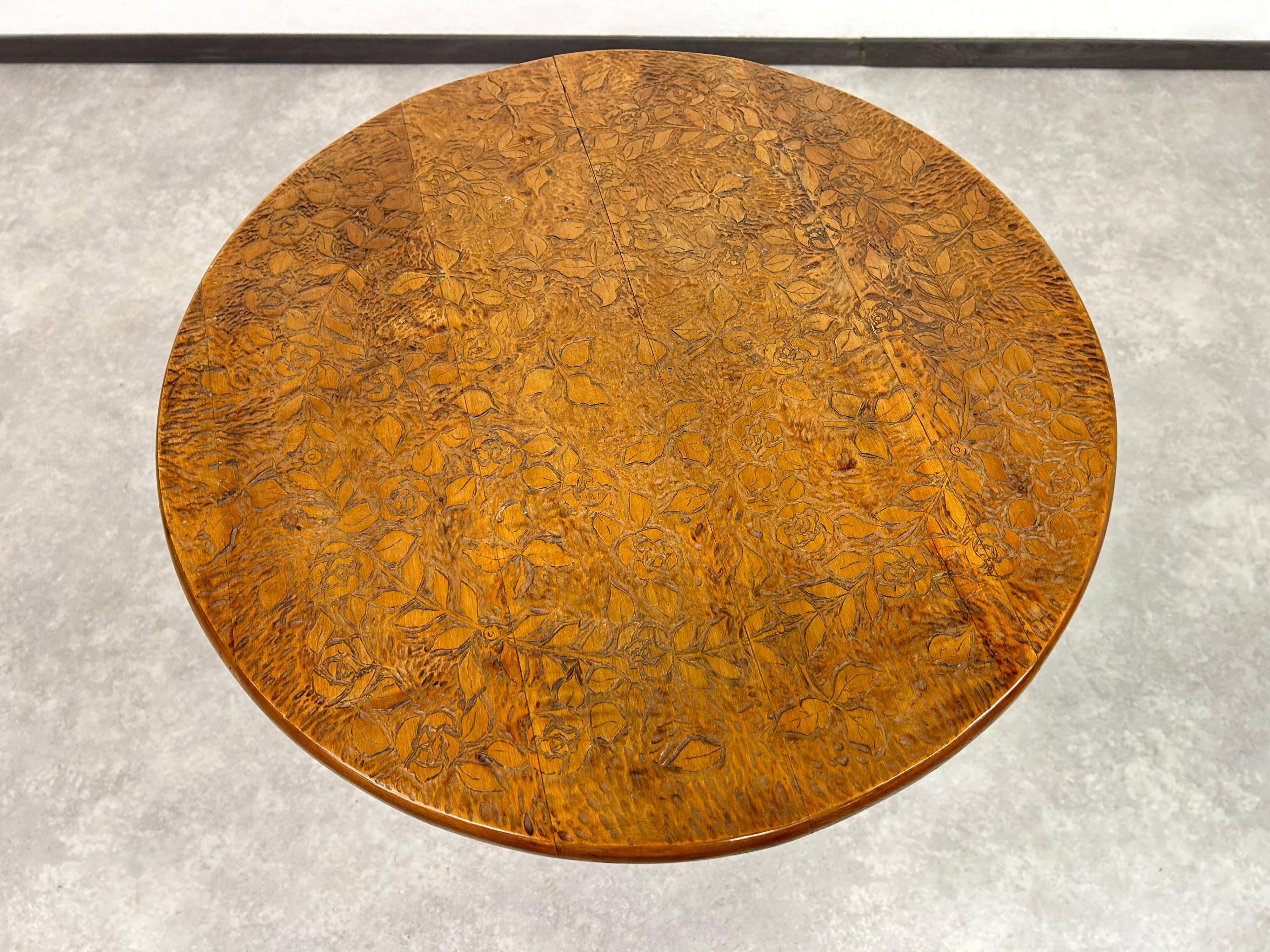Round Art Nouveau coffee table with a sculpted top.