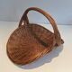 Woven Rattan Log Holder in a Semi-Round Shape with a Central Arched Handle.