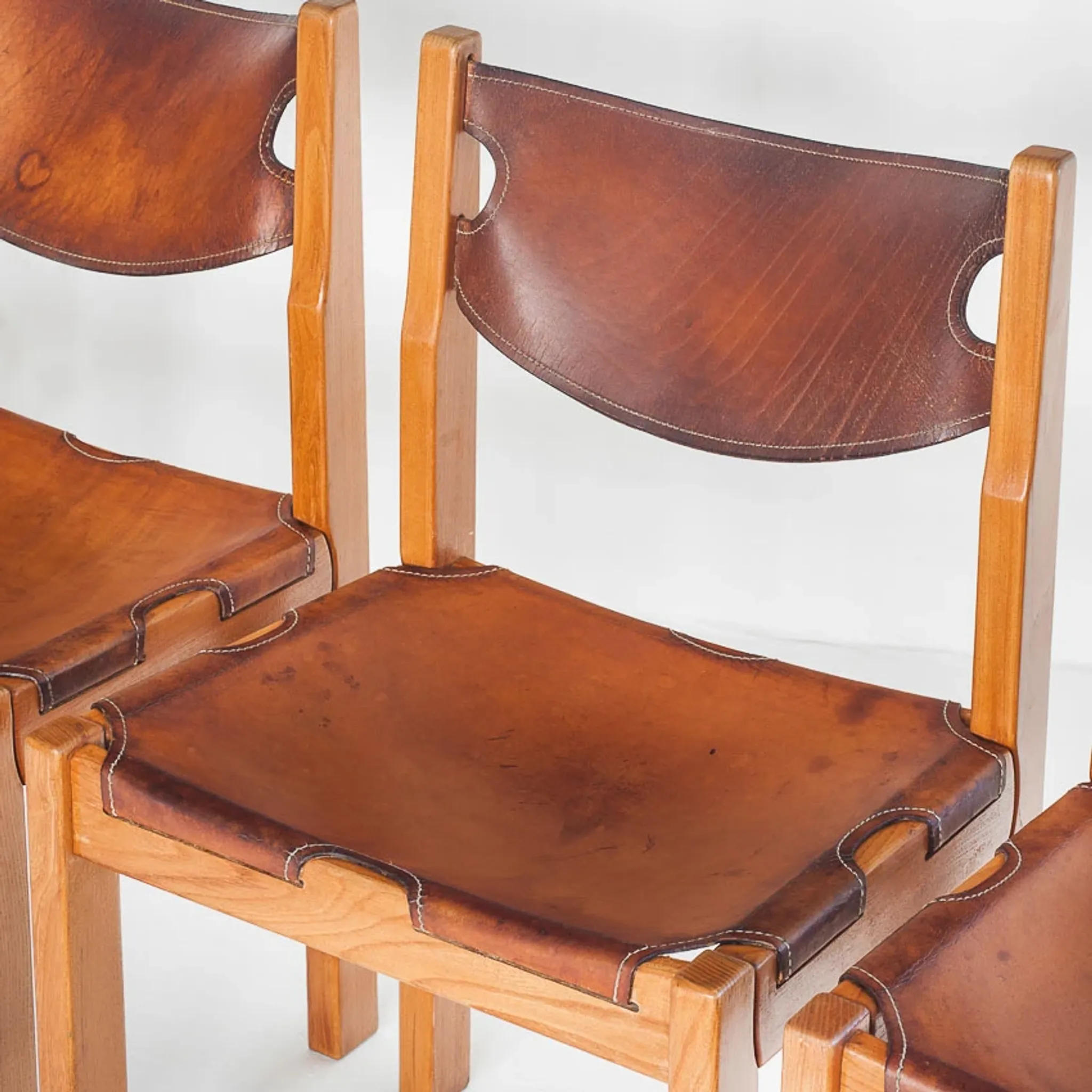 Ensemble de quatre chaises vintage. Bois d'orme et cuir. Maison Regain 70s