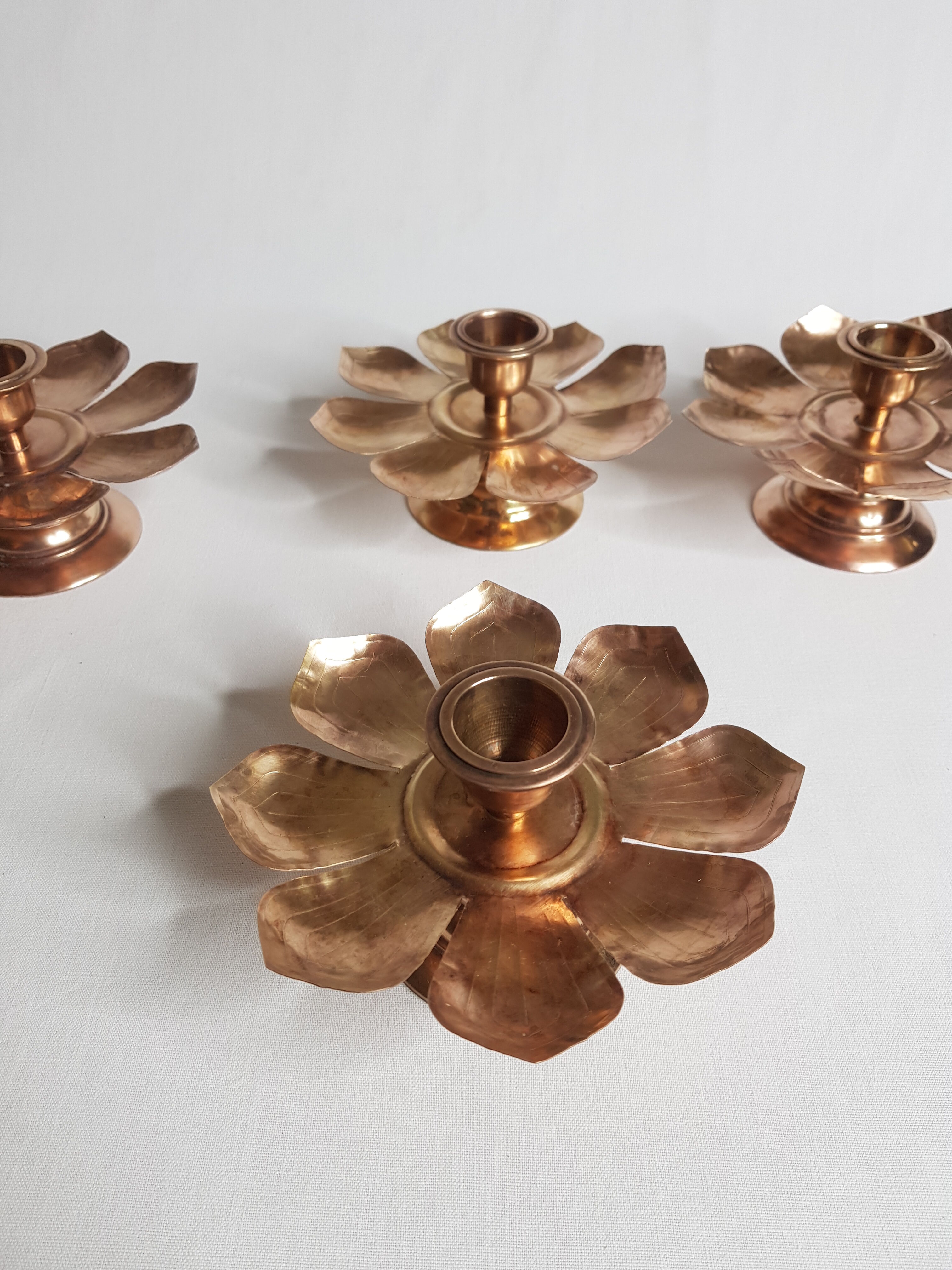 Set of four copper candlesticks in the shape of lotus flowers