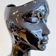 Black ceramic vase with a woman's face.