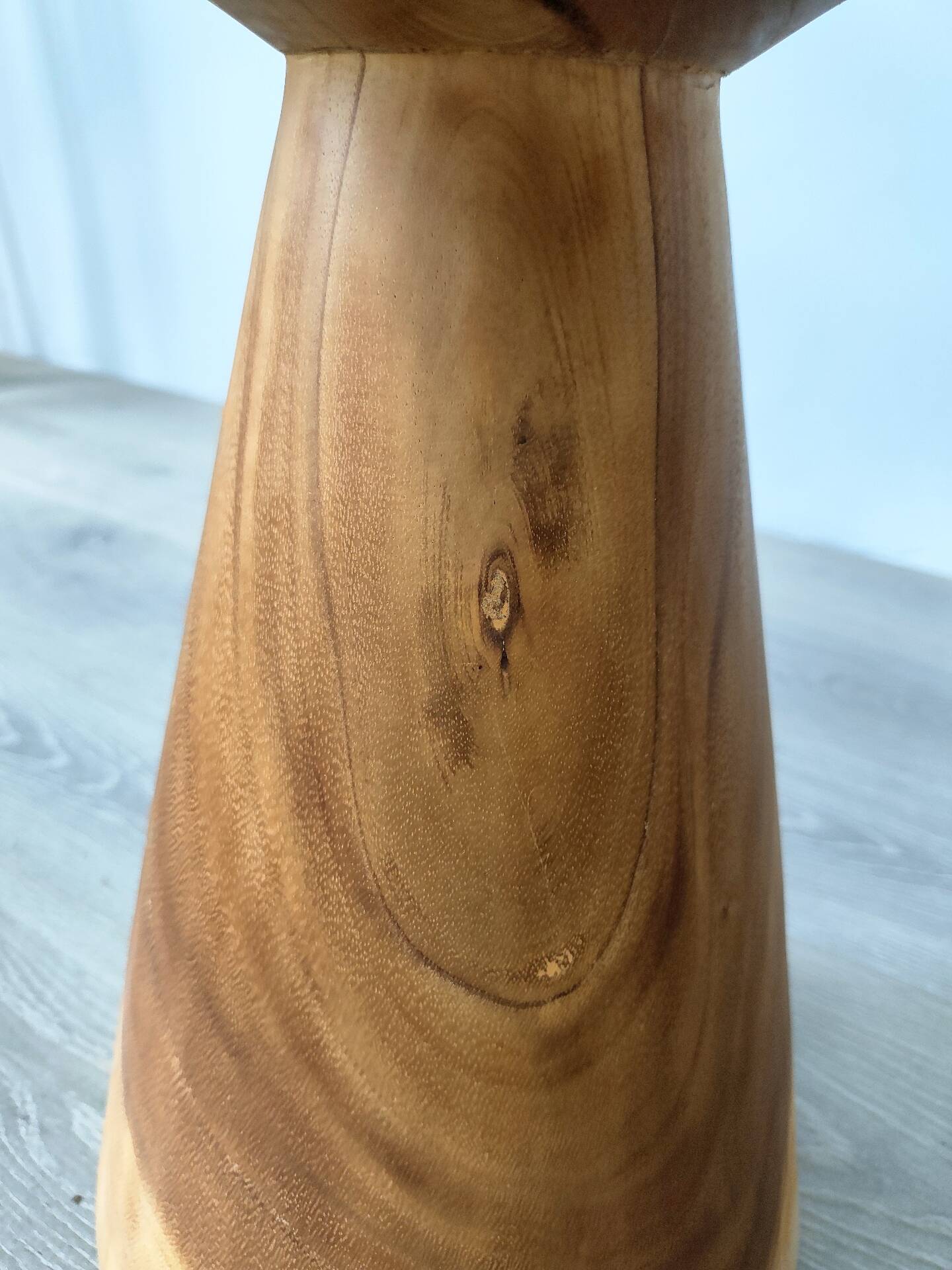 Minimalist side table in solid suar wood with conical legs.
