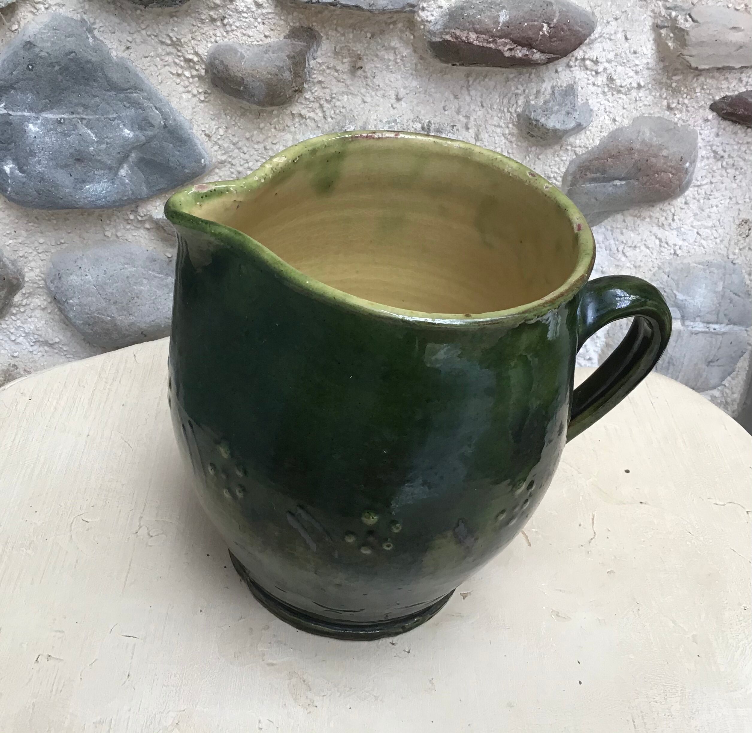Green varnished earth pitcher with flower pattern