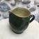 Green varnished earth pitcher with flower pattern