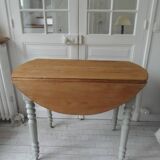 Walnut table with raised flaps, base on verdigris casters.