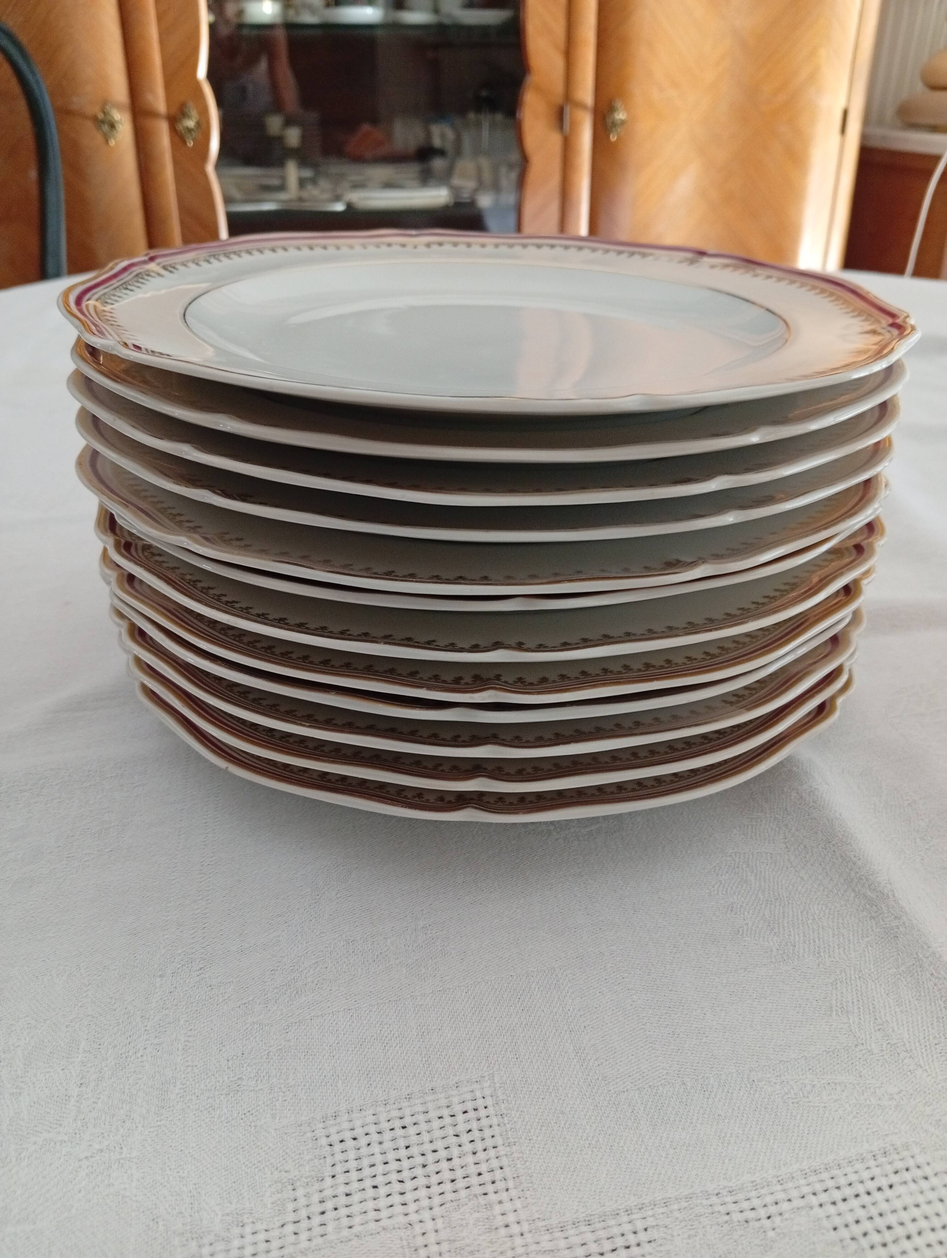 Set of 12 stylised white porcelain dinner plates, signed.