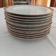 Set of 12 stylised white porcelain dinner plates, signed.