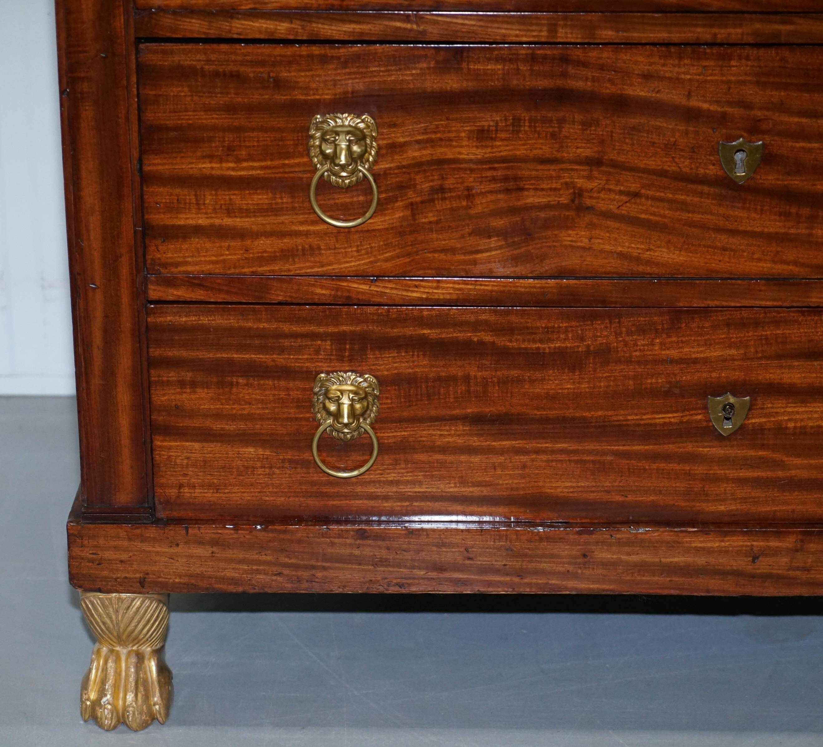 19th-century Empire commode with a marble top and lion paw feet.
