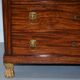 19th-century Empire commode with a marble top and lion paw feet.