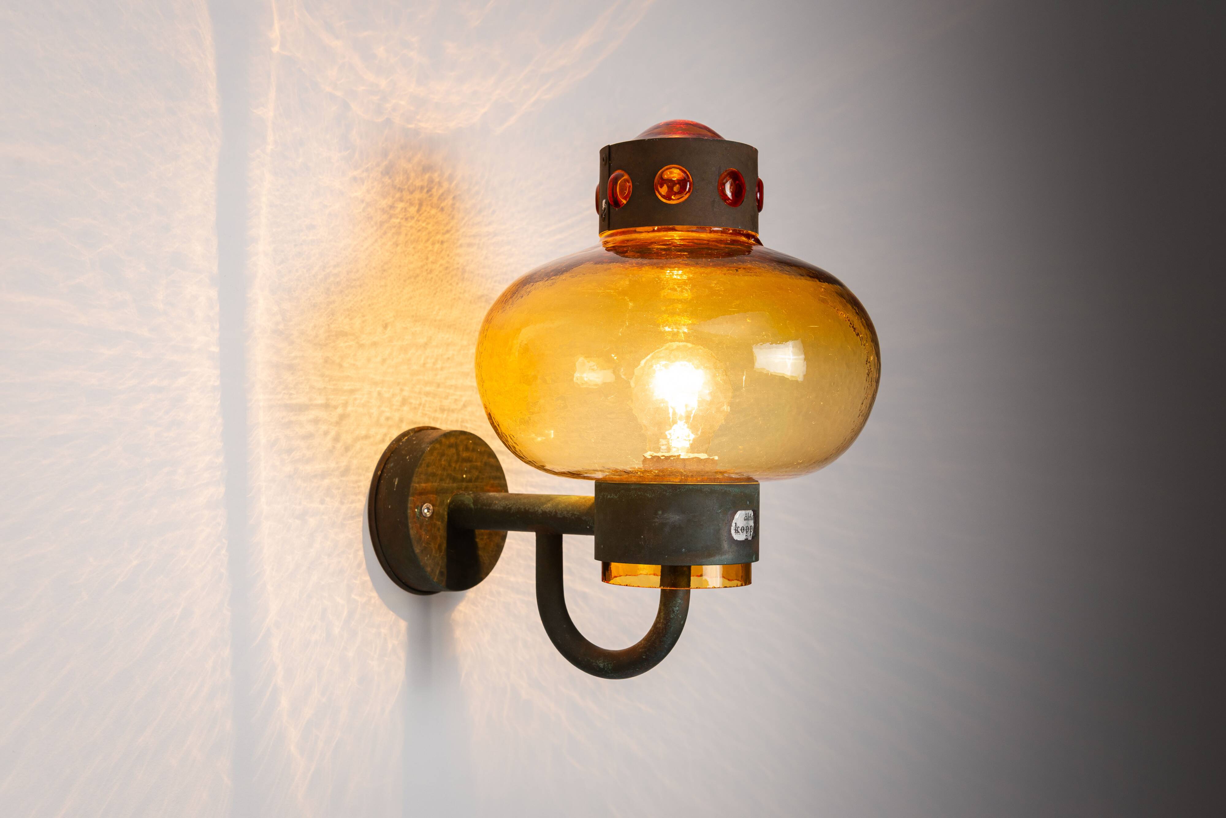 Pair of brass wall lamps with decorated amber coloured shades