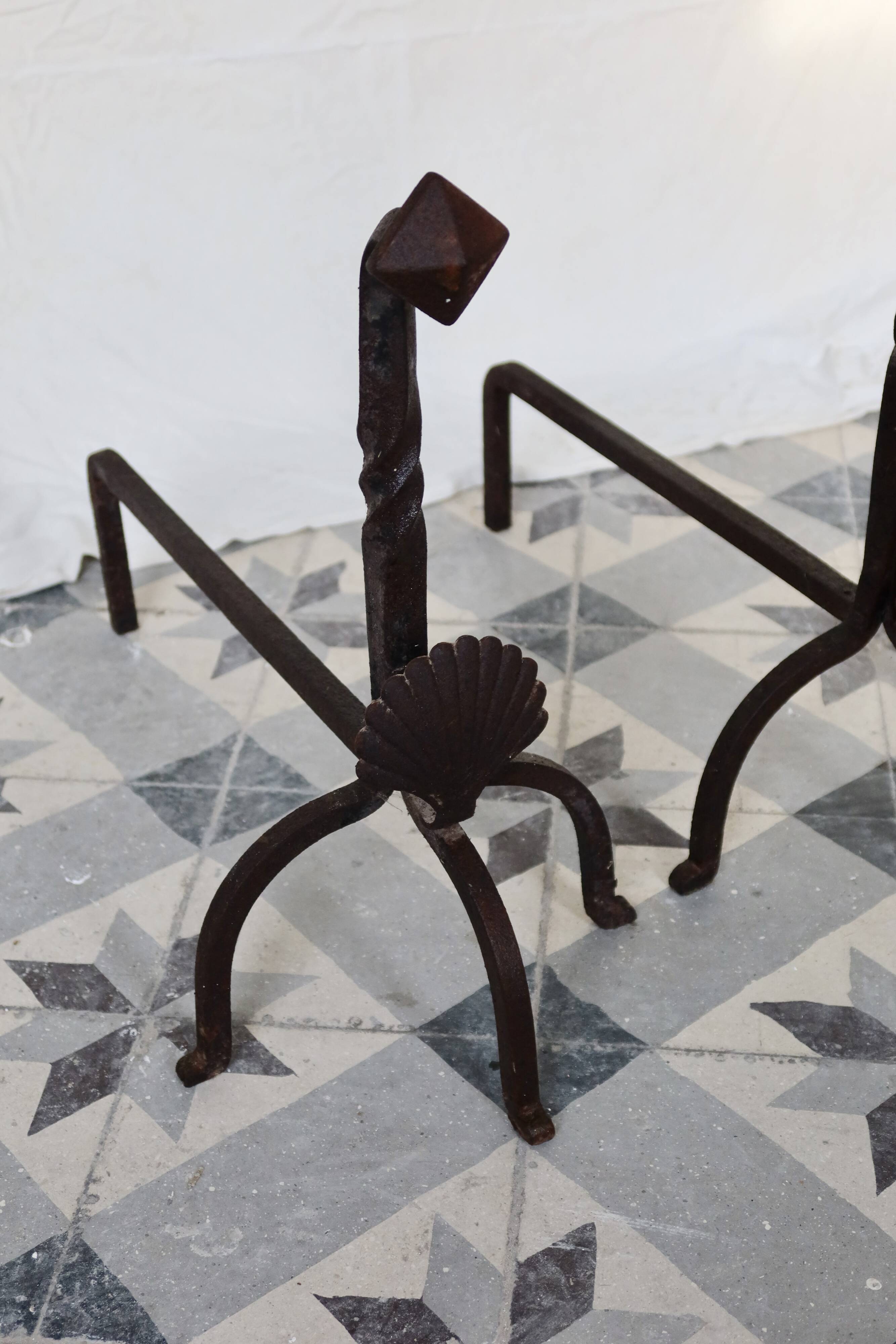 Vintage metal and cast iron fire dogs with shell motif.