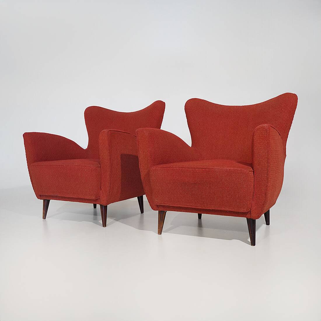 Pair of red armchairs with cone-shaped feet, 1950s