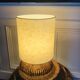 Table lamp with rattan base and papier-mâché hat