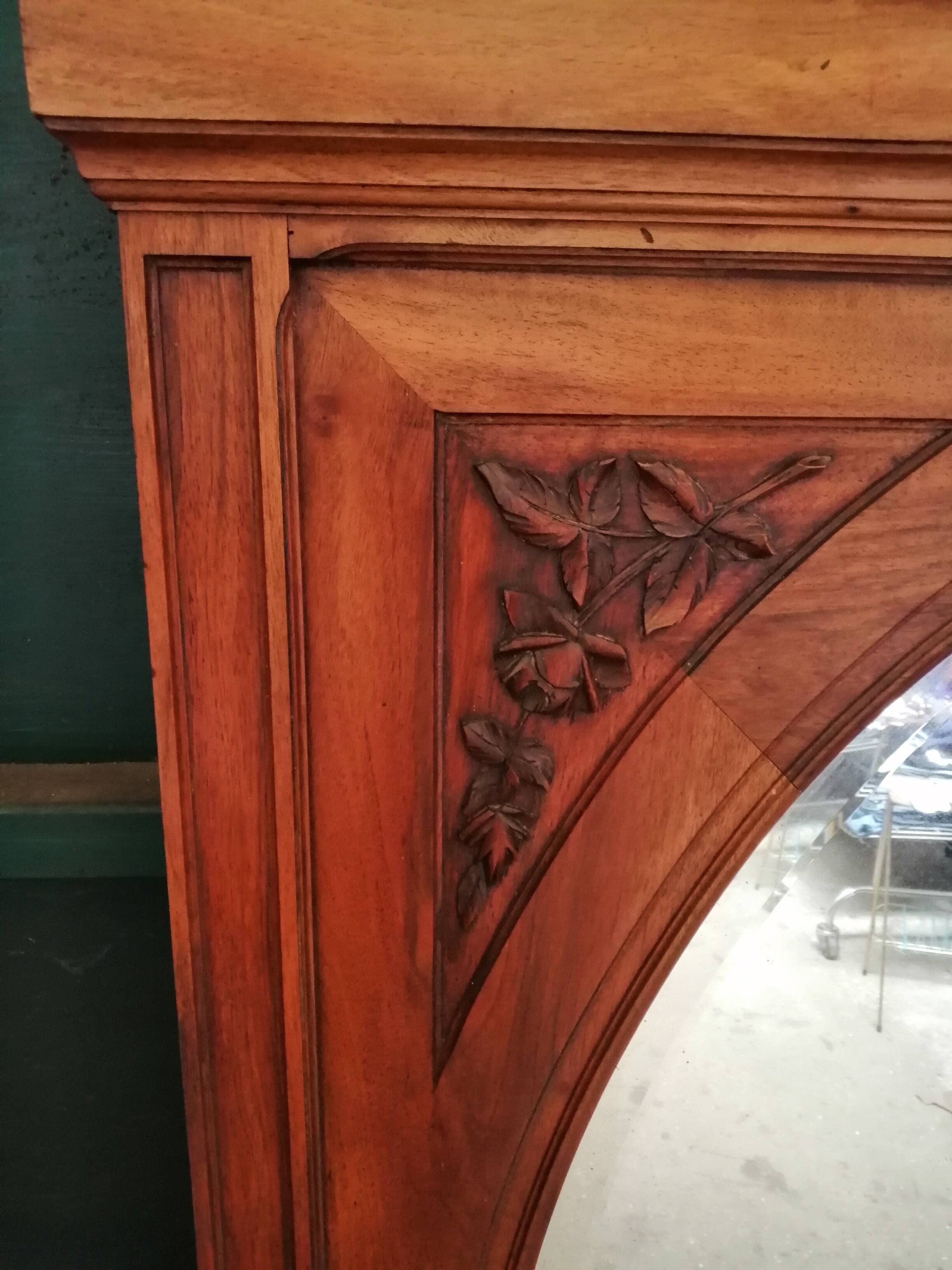 Old oval walnut wood mirror has flower carvings decoration