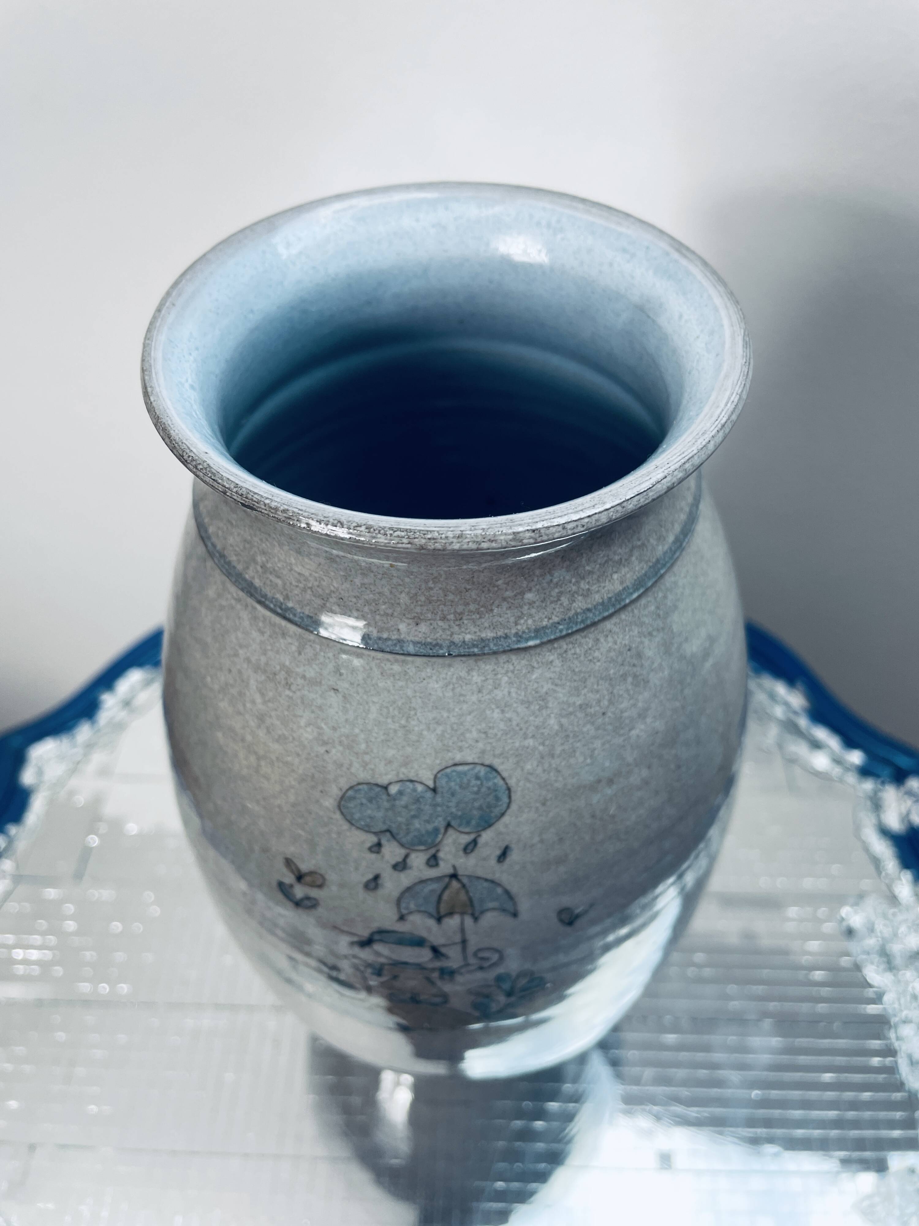 Handcrafted gray stoneware vase with child illustration