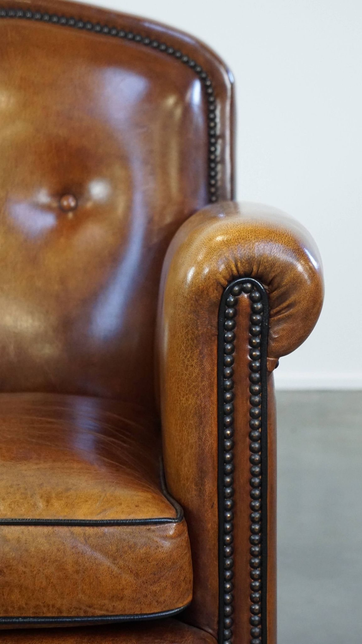 Sheep leather design armchair finished with decorative nails and black piping
