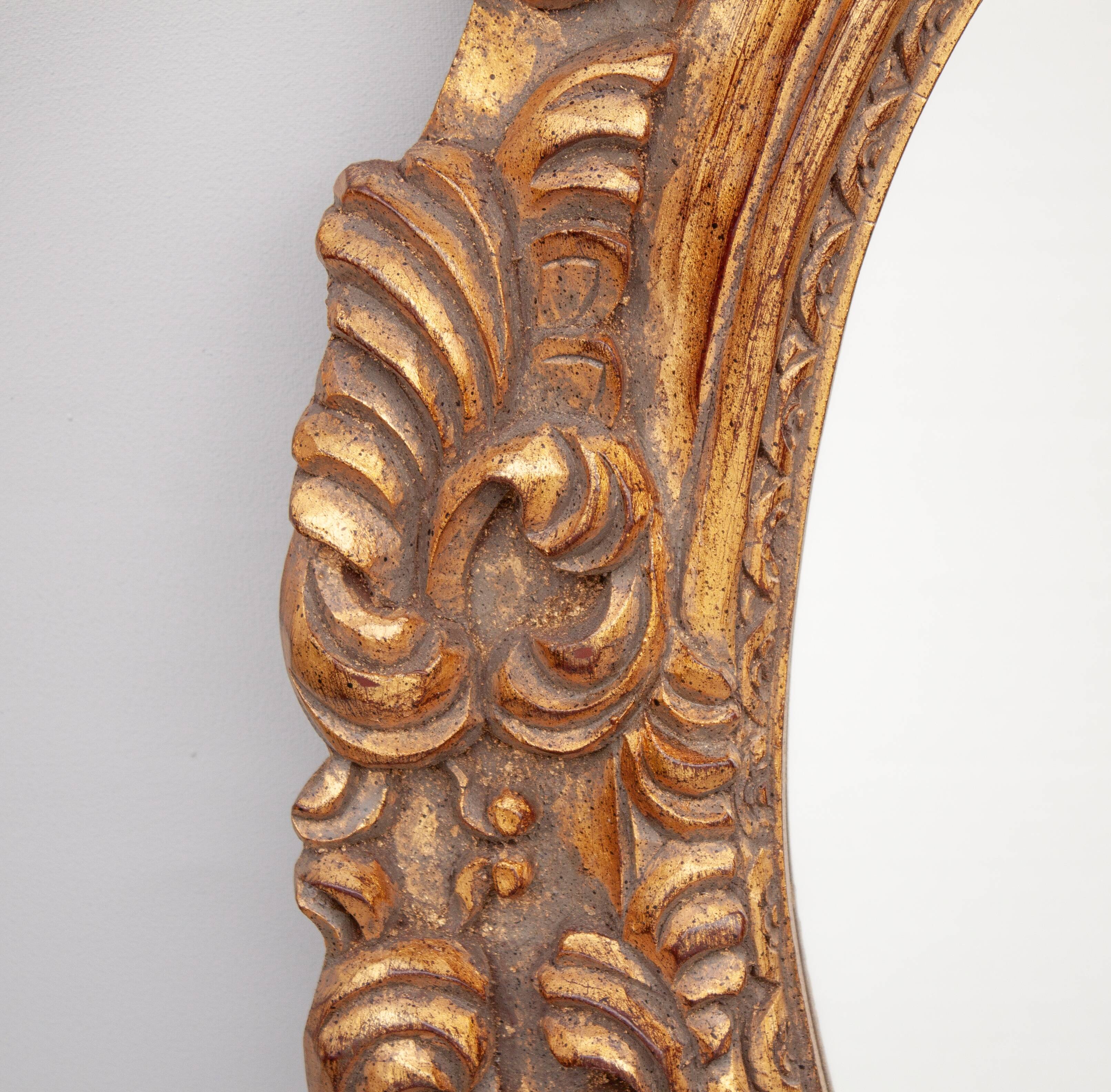 Oval mirror in gilded and carved wood. Vintage mirror. Wall mirror.