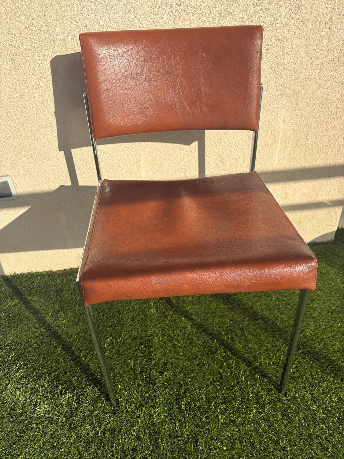 A pair of vintage brown Skaï chairs.