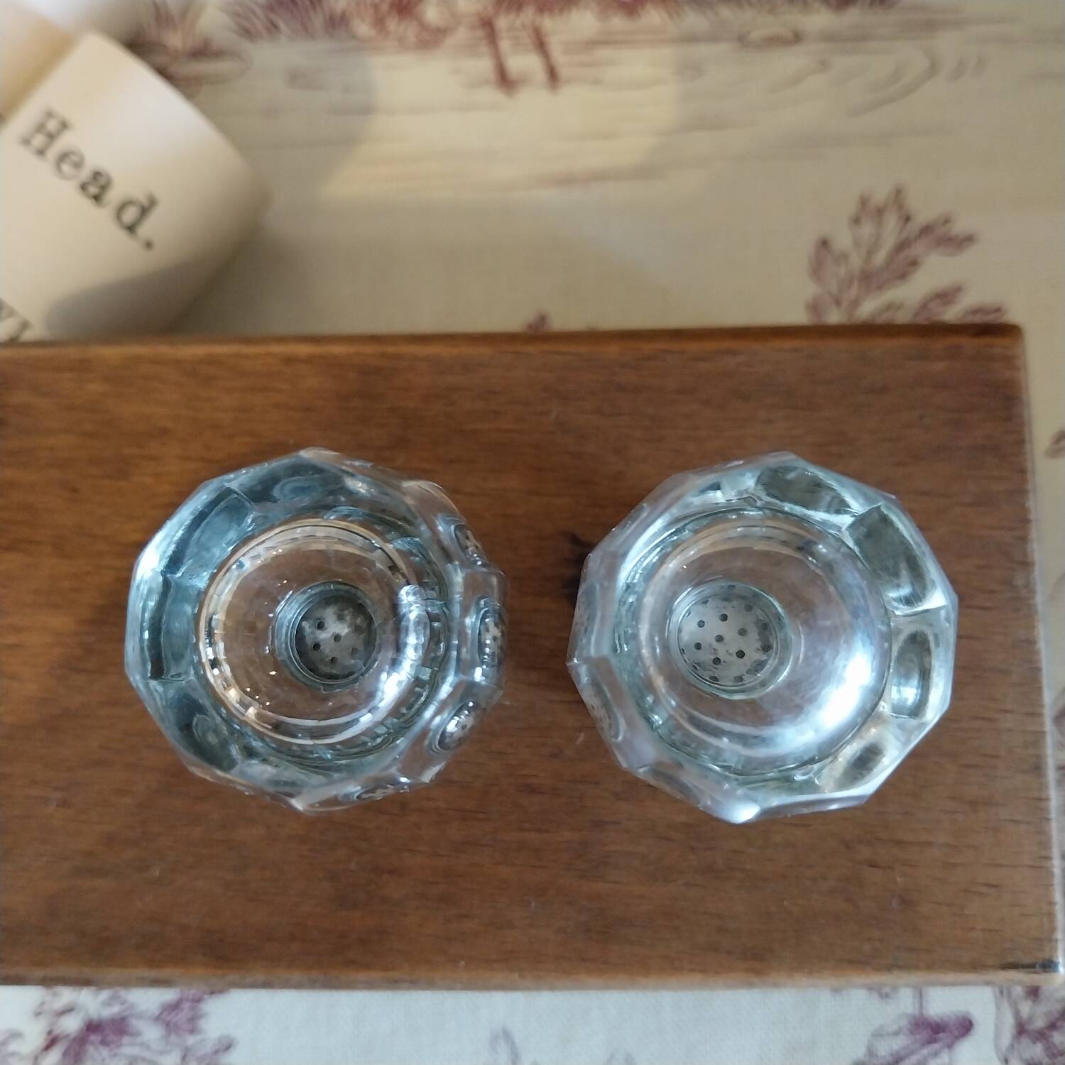 Antique salt and pepper shakers in crystal and silver metal.