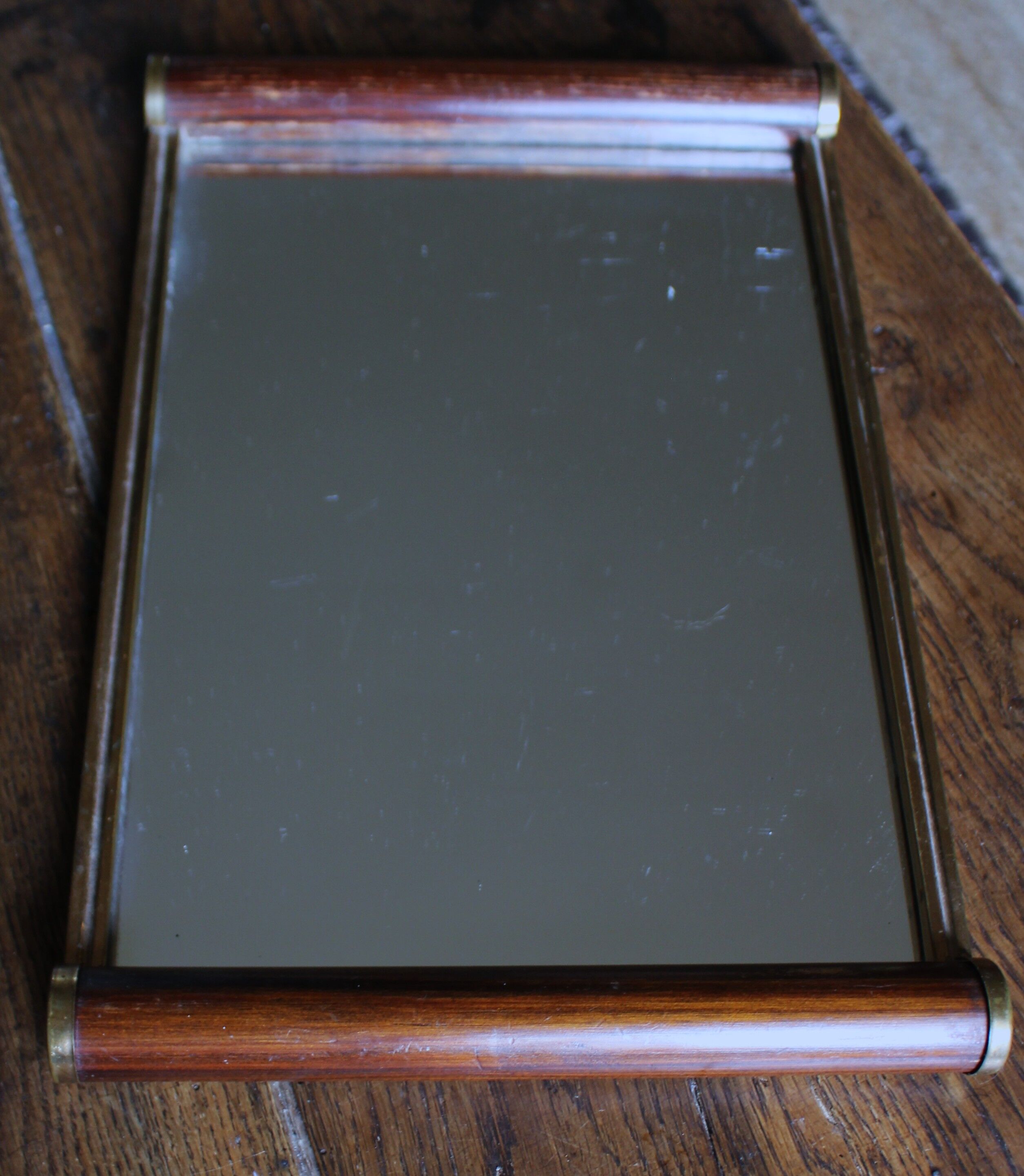 Rectangular mirror tray with wooden handles and gilding.