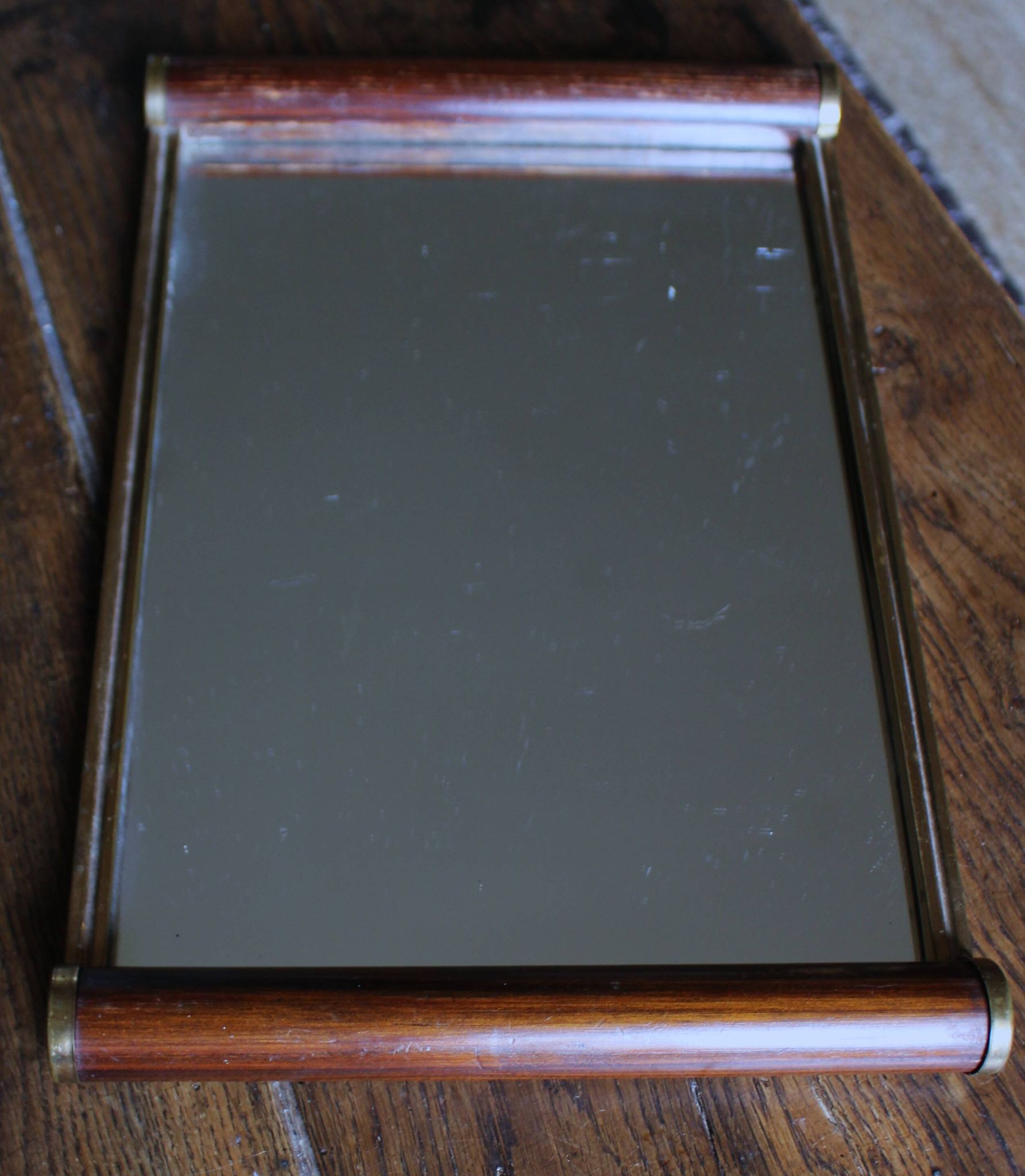 Rectangular mirror tray with wooden handles and gilding.