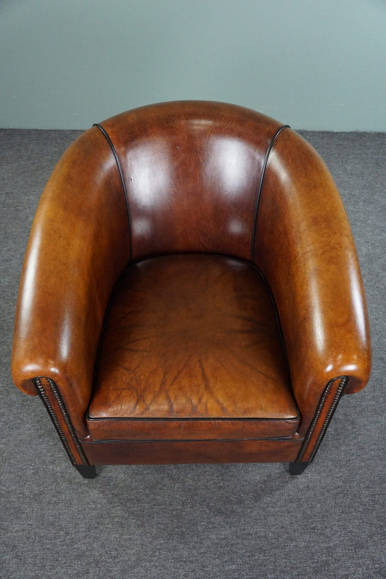 Club armchair in sheepskin with black piping
