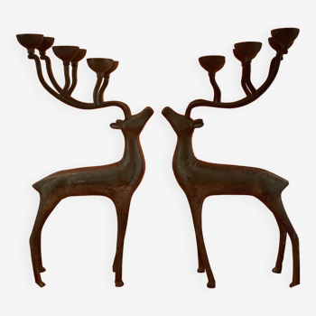 Two candlesticks, metal candle holders, in the shape of silver-colored deer
