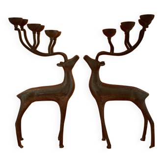 Two candlesticks, metal candle holders, in the shape of silver-colored deer