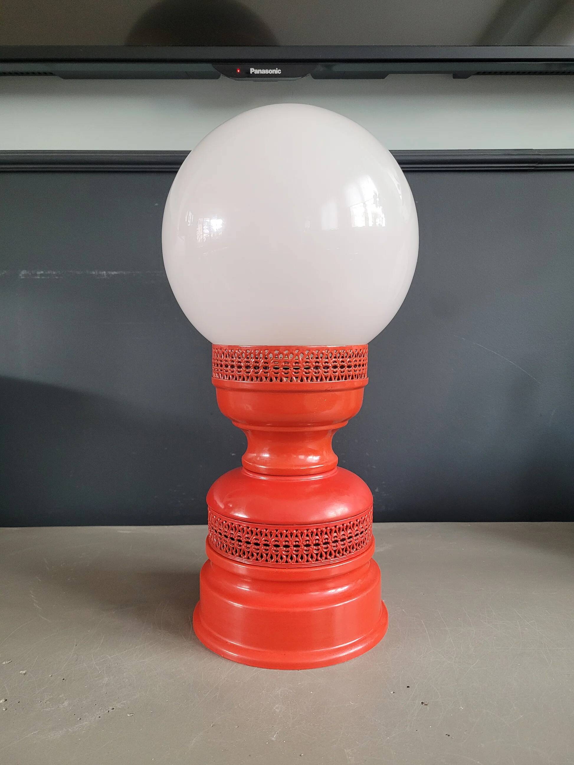 Vintage globe lamp with a metal base, perforated and lacquered in red.