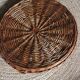 Large round dark wicker tray with two handles.