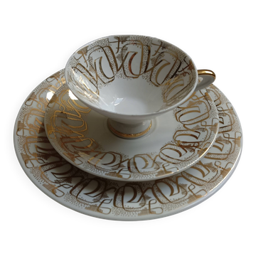 Solitaire tea cup, saucer, and dessert plate in white and gold.